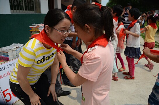 捐贈儀式上，孩子們?yōu)閻坌奶焓瓜瞪霞t領(lǐng)巾