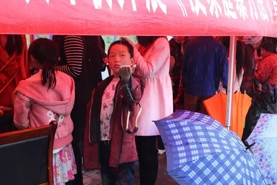 因為雨下的太大，小男孩玩起了接水游戲。