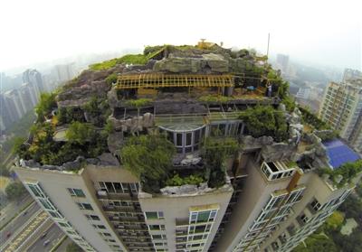 　　昨日，身穿橘黃色馬甲的工作人員在人濟山莊樓頂拆除違章建筑。新京報記者 吳江 攝