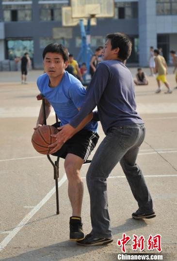 圖為拄著拐杖的瞿詩濤和同學(xué)搶球。劉占昆攝