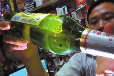 這瓶未開(kāi)封的燕京啤酒內(nèi)有一顆黑色懸浮物。京華時(shí)報(bào)記者 徐曉帆 攝