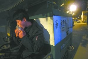 快遞哥抽空吃?xún)煽跂|西。記者 李剛 攝