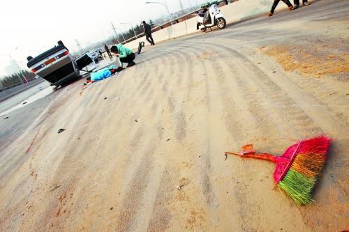 被撞的環(huán)衛(wèi)工躺在地上，身上蓋著藍(lán)色布?jí)K，現(xiàn)場(chǎng)除散落的汽車(chē)碎片外，還留有被撞斷的掃帚。