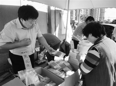 昨日，河南企業(yè)家劉春喜在京“練攤”，為顧客挑選綠豆。新京報記者 張玉學 攝