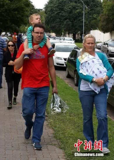 圖為一個(gè)白人家庭，由父母帶著孩子到曼德拉家門外悼念。中新社發(fā) 宋方燦 攝