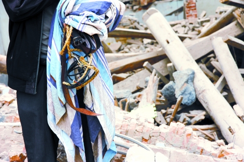 老人手中拿著曾控制住他的電線、床單