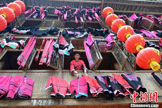 圖為紅瑤姑娘把紅衣晾曬出來(lái)。中新社發(fā) 韋吉陽(yáng) 攝