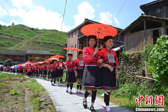 圖為新娘身著瑤族盛裝在伴娘和親友的陪伴下“出嫁”。中新社發(fā) 韋吉陽(yáng) 攝