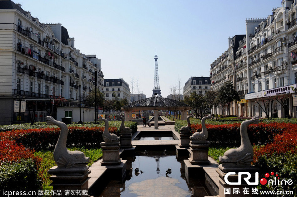 　2014年3月21日，杭州天都城，農(nóng)民在山寨埃菲爾鐵塔下耕作。圖片來源：東方IC