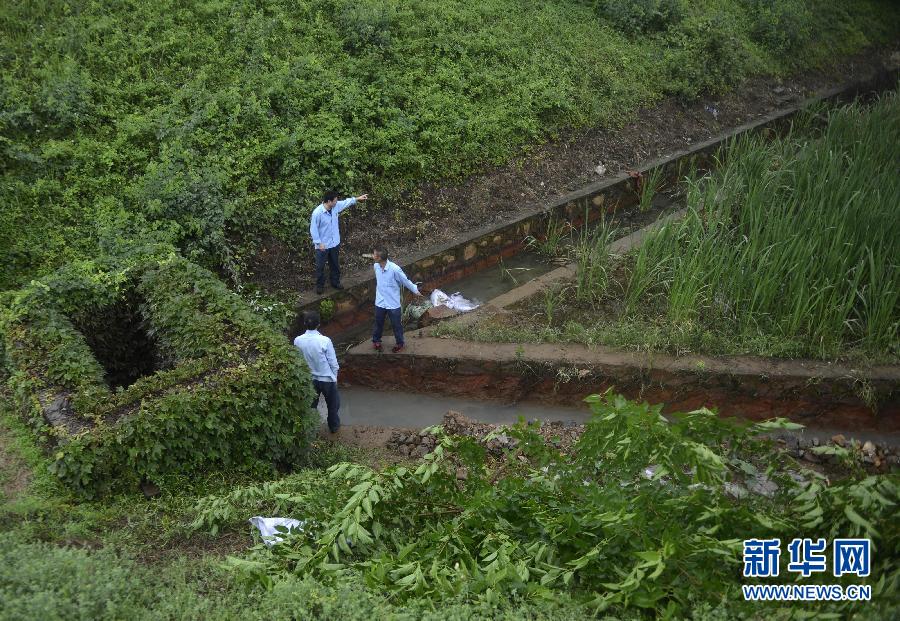 5月18日，工作人員在槽罐車泄漏現(xiàn)場附近的水渠邊查看情況。