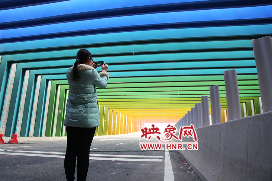 一女孩拿出手機(jī)拍照。