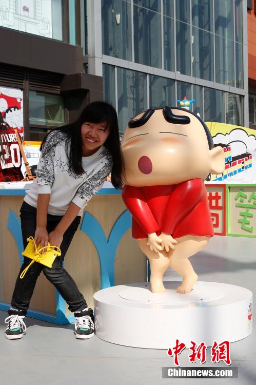 4月22日，游客與蠟筆小新合影?！跋灩P小新25周年紀(jì)念特展”日前在北京開展，吸引了不少市民游客。
