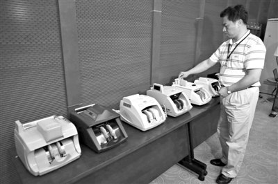 昨日，央行工作人員用各種驗(yàn)鈔機(jī)對(duì)C1F9假幣進(jìn)行測(cè)試，機(jī)器均能及時(shí)作出異常報(bào)警反應(yīng)。新京報(bào)記者 浦