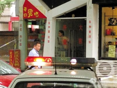 闖入面館的持刀男子與趕來的民警隔著玻璃門對(duì)峙，后店內(nèi)一名女童被其劫持。網(wǎng)友供圖