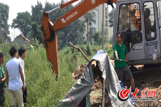 陳寶成手持自制刀斧守在挖掘機旁阻止便衣民警靠前。駕駛室內(nèi)，張朋珂正向受害人郭曉剛身上澆汽油。（視頻截圖）