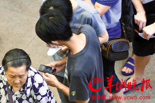 排隊的“黃?！备魇謭?zhí)一疊白紙，上面寫好了要掛號的人的信息，包括姓名、電話、要掛的科室等。穿黑白花紋衣服的老婆婆正在排隊掛號