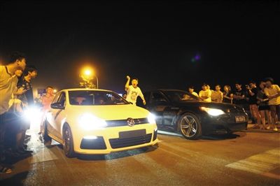 8月24日晚，東壩中街飆車現(xiàn)場(chǎng)，兩輛車并排等待出發(fā)指令，旁邊許多愛(ài)好者前來(lái)觀看比賽。新京報(bào)記者