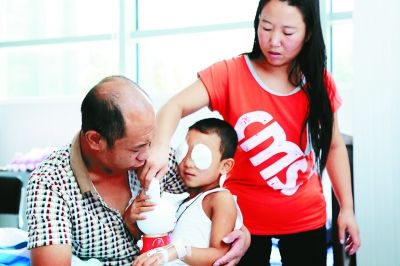 斌斌手術(shù)后第一天恢復(fù)良好，斌斌父母在用玩具逗他開心供圖/嚴(yán)益