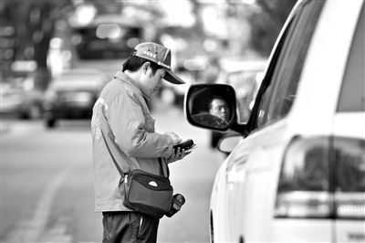 10月15日，朝陽區(qū)東大橋路，停車管理員從腰間掏出一個專用POS機，正在錄入停車信息。新京報記者 周崗峰 攝