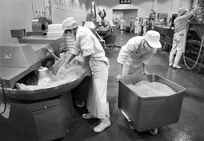 昨日，位于順義李遂開(kāi)發(fā)區(qū)的慶豐包子鋪配送中心生產(chǎn)車間，工人們正在斬拌胡蘿卜餡料。