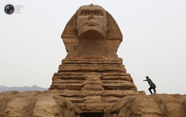 石家莊郊外，一名男子與山寨版獅身人面像合影留念。