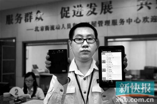 　越秀區(qū)北京街出租屋外來暫住人員管理服務(wù)中心的工作人員展示到出租屋登記來穗人員信息的儀器。