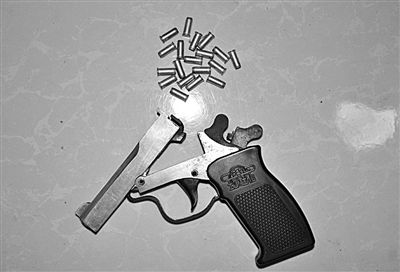 警方從搶劫嫌疑人處起獲的贓款和發(fā)令槍、子彈。警方供圖