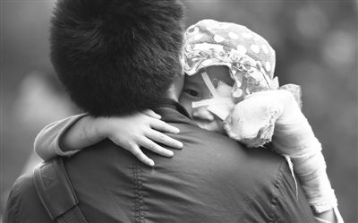 昨日，北京同仁醫(yī)院，被砍傷的彤彤趴在舅舅的肩上。他們剛剛掛完號(hào)，正準(zhǔn)備回旅館。新京報(bào)記者 尹亞飛 攝