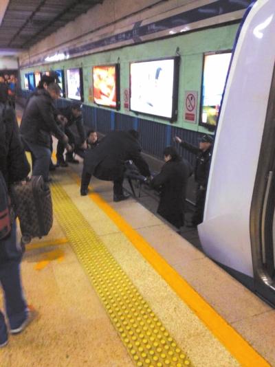 地鐵工作人員將林某從站臺下救起。網(wǎng)友供圖