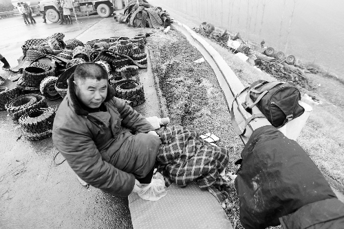 　出事司機(jī)的鞋找不到了，只好用塑料袋套著腳取暖