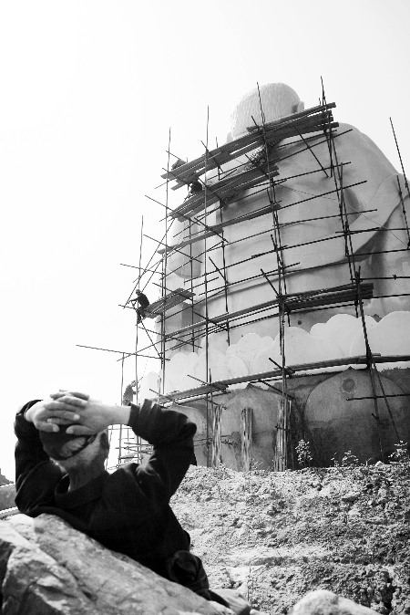 今年4月26日，工作人員將帆布蓋在“佛像”頭像上