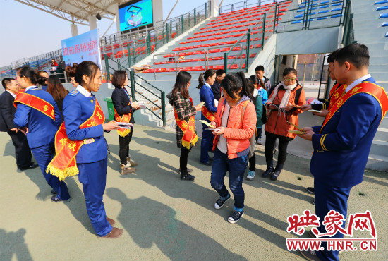 活動(dòng)現(xiàn)場(chǎng)工作人員給同學(xué)們發(fā)放宣傳冊(cè)、環(huán)保袋。