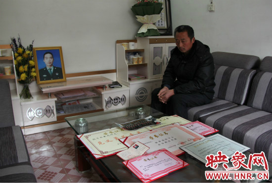 救火英雄鄭春光的父親和兒子獲得榮譽(yù)證書。