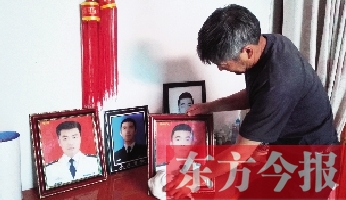 沉浸在悲痛之中的魯有海，擦拭著孩子的遺照