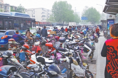 省人民醫(yī)院北門，路邊的公交站牌處停滿非機動車，上、下客只能在快車道上。