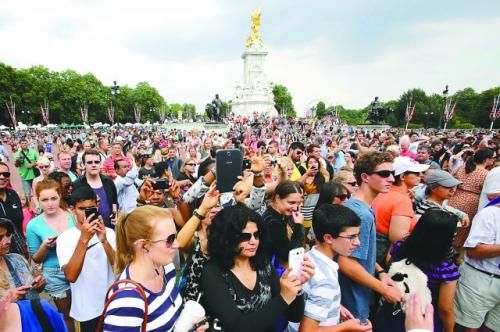 7月23日，在英國倫敦白金漢宮外，民眾們爭相閱讀“王室寶寶”出生的正式公告。