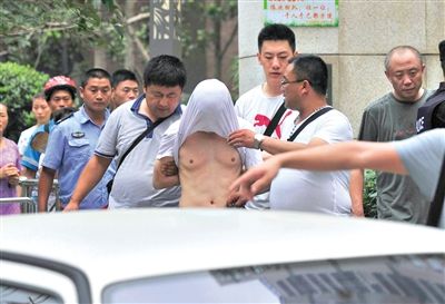 昨日，成都警方抓捕時與毒犯發(fā)生槍戰(zhàn)。一名男犯罪嫌疑人被警方押出。