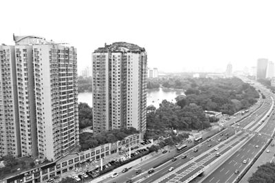 昨日，人濟(jì)山莊小區(qū)，與其他樓相比，B棟樓頂層天臺(tái)上違規(guī)建造了一棟兩層小樓，假山大樹(shù)俱全。新京報(bào)記者