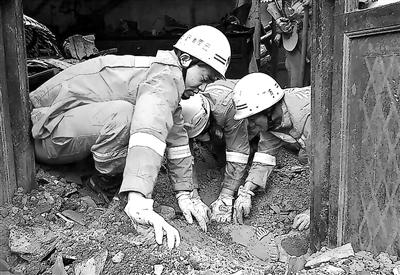 救援人員用手刨出遇難者 供圖/新華 救援人員用手刨出遇難者 供圖/新華