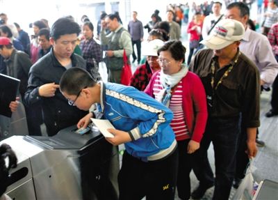 去年5月5日，14號線園博園站，乘客刷卡出地鐵。北京公交地鐵將實行計程票制，多乘坐多付費。