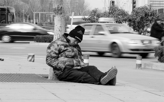 2月2日，鄭州市中州大道農(nóng)業(yè)路立交橋下，50歲的王文德打算在臨近春節(jié)前再接些零活兒，由于疲憊，他睡著