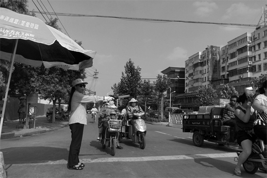 昨日，開封市區(qū)一名協(xié)管員在指揮群眾過馬路