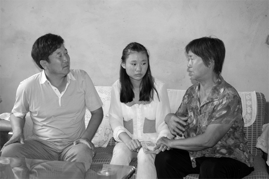 “商丘最美女兒”李丹（中）捐骨髓救母，愛(ài)心人士（左）送來(lái)1萬(wàn)元愛(ài)心款