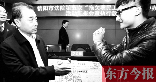 張立勇將依法執(zhí)行回來的農(nóng)民工工資發(fā)放給案件當事人游昌華，游昌華施以中國傳統(tǒng)作揖禮答謝