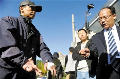 常林鋒在法院外展示雙手，他稱被燙傷的手因刑訊逼供且未得到及時救治