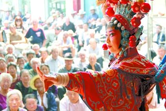 圖為8月15日戲曲演員在“流動舞臺車”上表演傳統(tǒng)地方戲《穆桂英下山》。