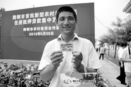 領(lǐng)到貸款，農(nóng)民開心地笑了。