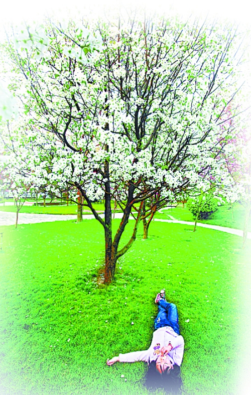 　孩子愜意地躺在社區(qū)內(nèi)的草坪上。