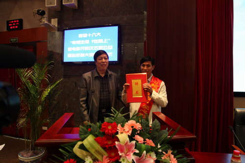 河南平頂山魯山縣電視臺的記者張朝岑，接過了河南電視臺9頻道總監(jiān)張克宣遞上的聘書。