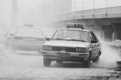 施工的道路上，車輛通過塵土飛揚。